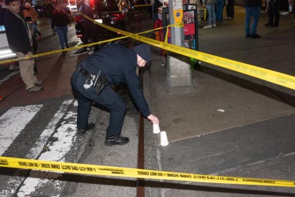 A police officer marks evidence after a woman was shot inside the JD Sports store on Broadway and 41st St. in Times Square on Feb. 8, 2024. (Gardiner Anderson for New York Daily News)